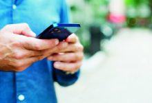 صورة مشاة يتصفحون «التواصل الاجتماعي» أثناء عبور الإشارات الضوئية